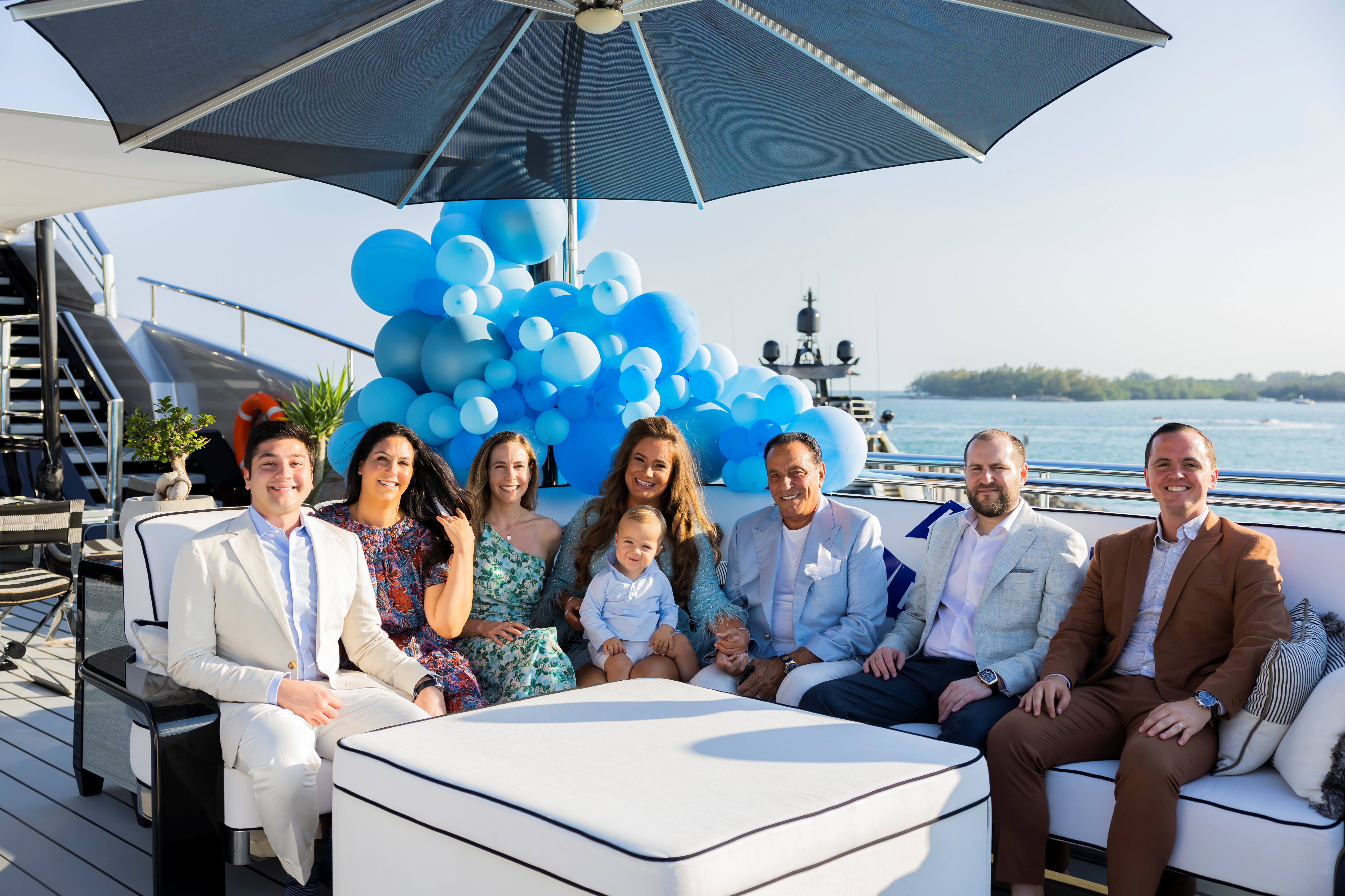 John Rosatti seated with family and friends aboard a yacht