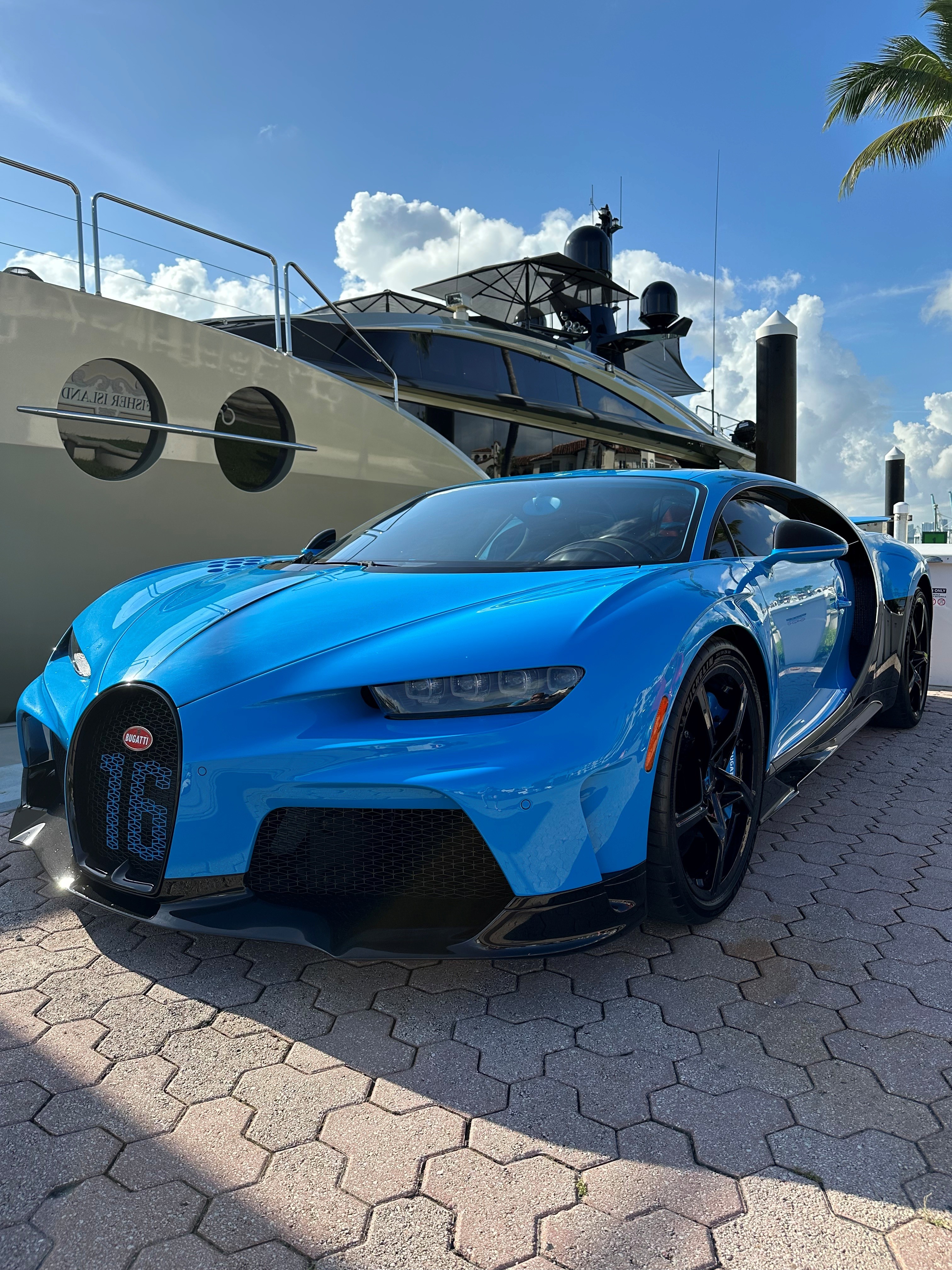 John Rosatti’s blue Bugatti photographed with a yacht on the Miami waterfront